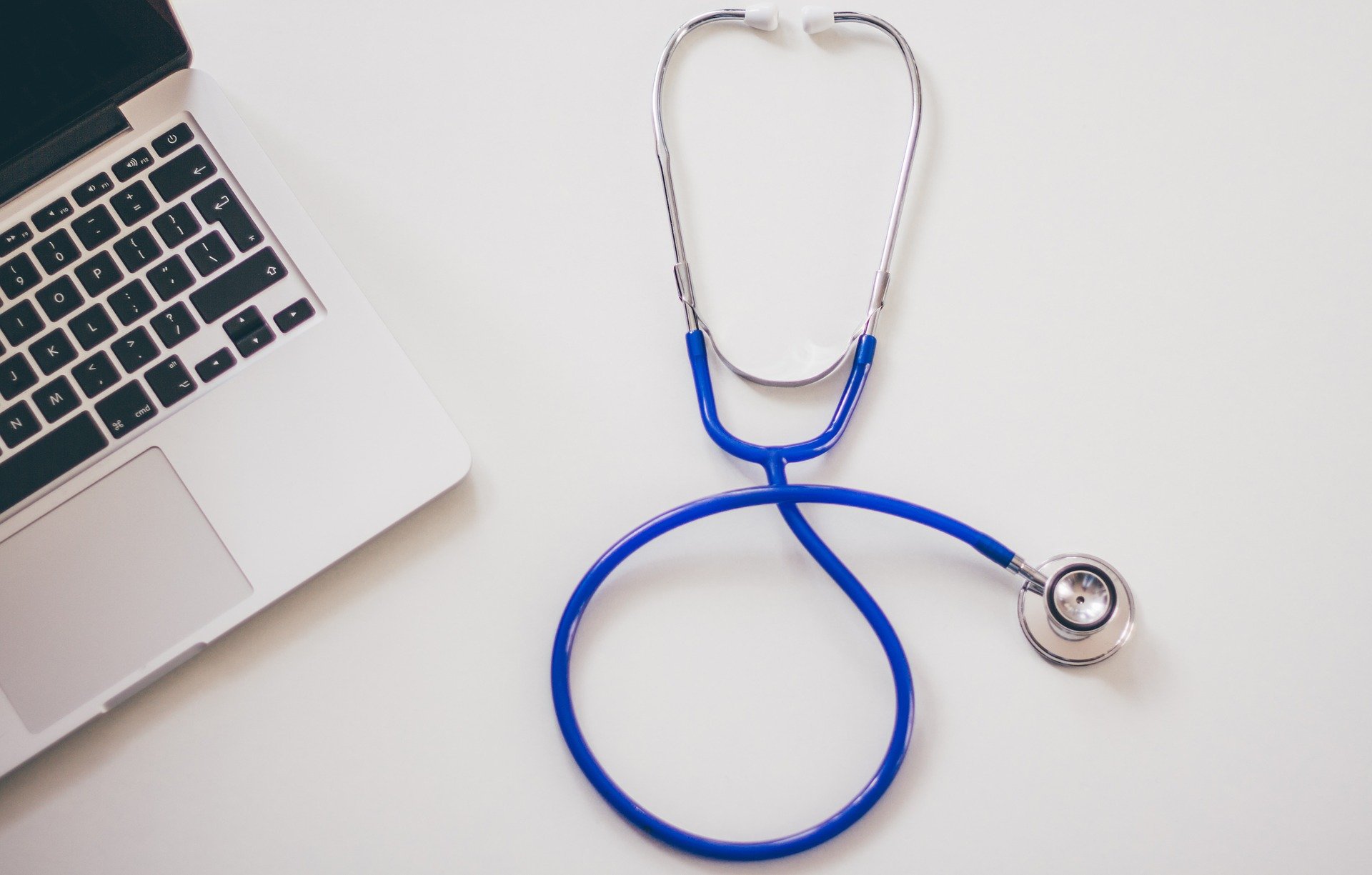 Computer and stethoscope on white desktop; representing a Health Savings Account (HSA)